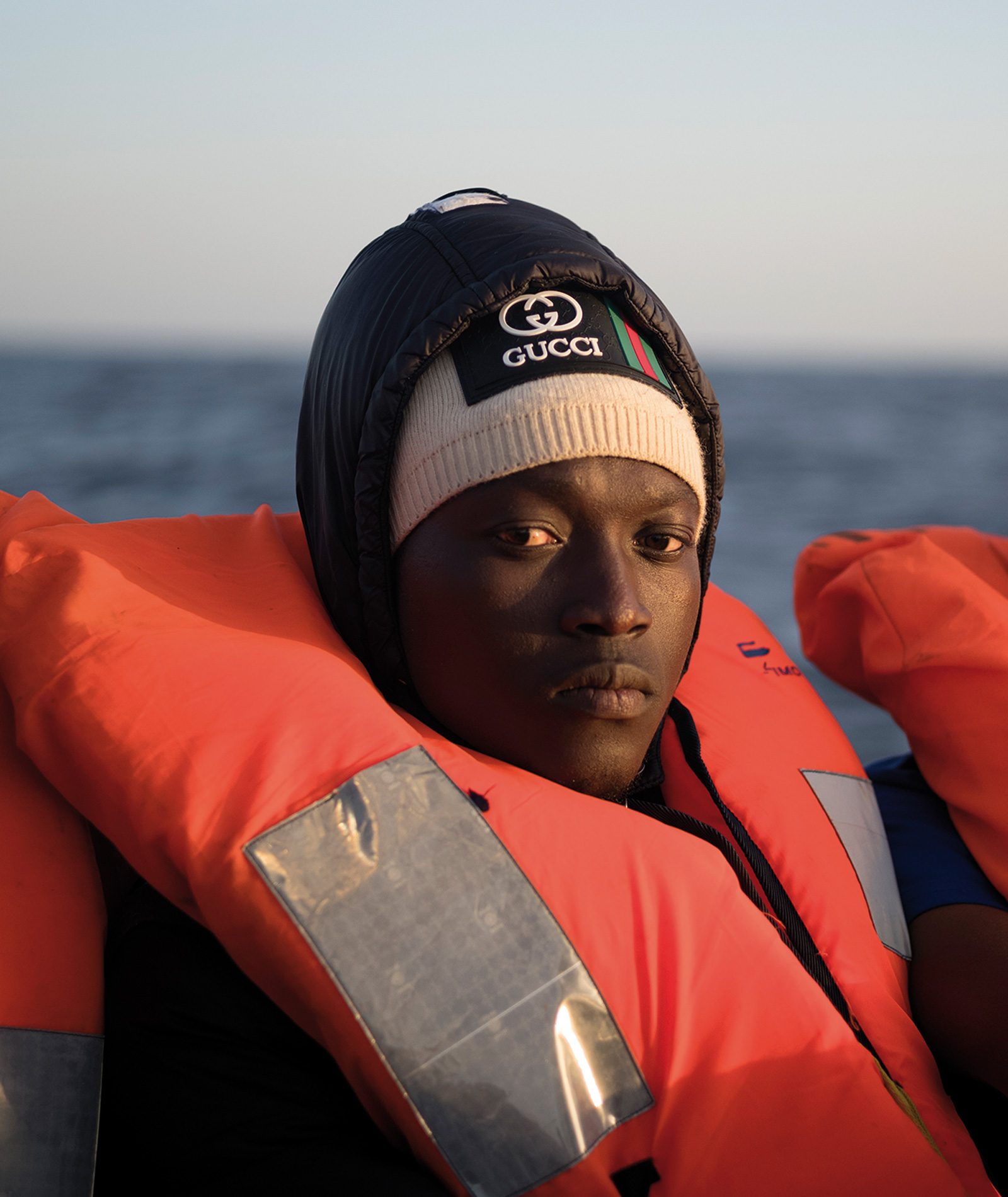 Ibrahima tittar in i kameran. Han har mössa och flytväst.